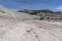 a motorcycle is parked on the dirt road in the middle of nowhere and rocky landscape