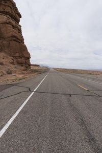 the white strip on this deserted road is very narrow for the motorcycle riders to travel