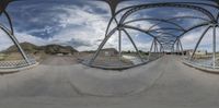 the 360 - turn view shows an intersection between a roadway and street bridge, near an old ranch