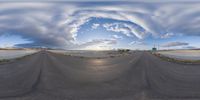 a distorted image of an asphalt road and sky in a convex lens style, the road is curved