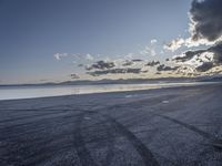 an empty beach with sky and clouds above it as seen from an open car port