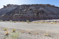 a small road in front of the rocky hills of an empty land with a motorcycle parked on it