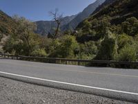 two bikers ride down the road towards the mountains in the valley on their bikes