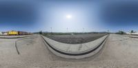 a fish eye view of a road under construction with a train on the railroad crossing