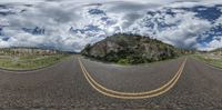 a 360 - view image of a winding road in the middle of nowhere under the cloudy sky