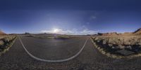 a very wide angle picture of the road to nowhere during the day time, on the edge of a mountain