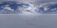 a sky with some clouds above a snow covered field and an empty area under it
