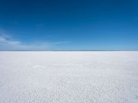 the empty snow field of a vast plain, looking at the sky and water below