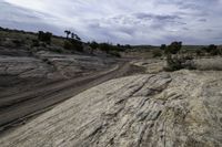 a view of rocks and a dirt road through it with a dark blue sky above