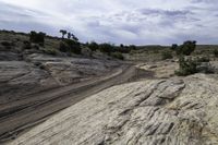 a view of rocks and a dirt road through it with a dark blue sky above