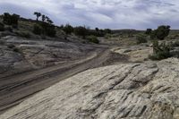 a view of rocks and a dirt road through it with a dark blue sky above