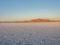 a snow skier coming off of the mountain in front of him in the desert area