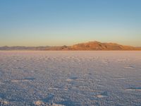 a snow skier coming off of the mountain in front of him in the desert area