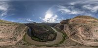 panorama view from bridge at canyons with river in foreground and mountains beyond against blue sky