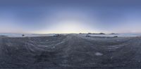 cars driving on a road near an icy field at sunset and sky with sun setting over mountains