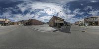 the view from across a city street through a fisheye lens, a person in motion on a bike, a man on a skateboard and buildings are sitting