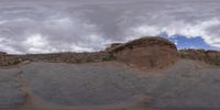 a panoramic view of a wide desert area with rocks, plants and dirt