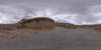 a panoramic view of a wide desert area with rocks, plants and dirt