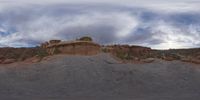 a panoramic view of a wide desert area with rocks, plants and dirt