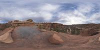 a panoramic view of a wide desert area with rocks, plants and dirt