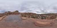 a panoramic view of a wide desert area with rocks, plants and dirt