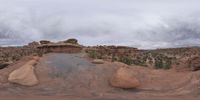 a panoramic view of a wide desert area with rocks, plants and dirt