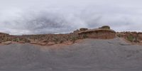 a panoramic view of a wide desert area with rocks, plants and dirt