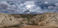 this is an image of a desert landscape with clouds in the sky and green vegetation