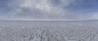 a large wide expanse of ice with a single person in the distance in the distance