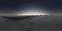 a long stretch of sand in a desert on an empty plain with several vehicles parked