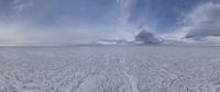 a white snowy landscape on a cloudy day with clouds above it and the sky in the center