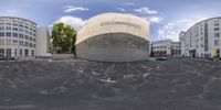 360 lens picture of an old, vacant parking lot with empty buildings in the background