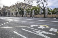 a person is crossing the street in front of an old building and cars on the street