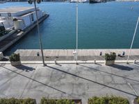 two benches are by a fence in the water next to a dock and several boats