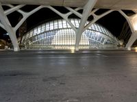 a city bus station with a long open roof by night time lighting on the streets