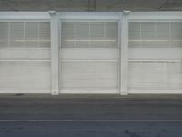 a view of a bench and several windows from inside a building, a red fire hydrant sitting beside it