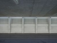 a view of a bench and several windows from inside a building, a red fire hydrant sitting beside it