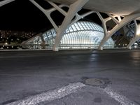 an empty city area with modern architecture at night by the sea and sky building lit up