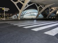 a city with a very tall structure and white crosswalks in front of it