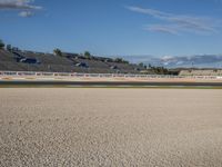 the green road and orange and white stripe line at an event near the racetrack and stadium