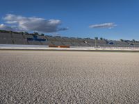 the green road and orange and white stripe line at an event near the racetrack and stadium