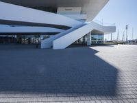 a concrete stairway leading to a white building with glass railings on the outside of it