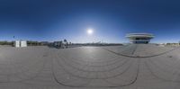 a fish eye lens captures an architectural building with a large circle outside it and a sky background