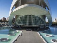 a modern building in spain with large, curved windows on the facade and walkway below