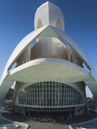 a modern building in spain with large, curved windows on the facade and walkway below