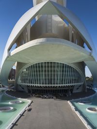 a modern building in spain with large, curved windows on the facade and walkway below