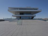 a very large building sitting next to some stairs in front of it by the water