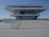 a very large building sitting next to some stairs in front of it by the water