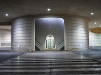 the outside of an empty building at night with a large lit doorway in the middle of the hallway