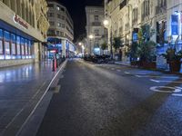 a city street is empty of pedestrians or cars at night time and traffic lights on